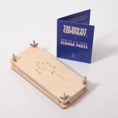 a notepad with a dandelion on it next to a flower press