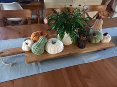 a wooden table topped with lots of different types of pumpkins