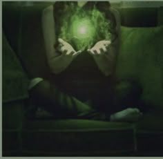 a woman sitting on a couch holding a green ball in her hands