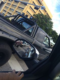 there is a truck that has its side mirror on the car's side view mirror