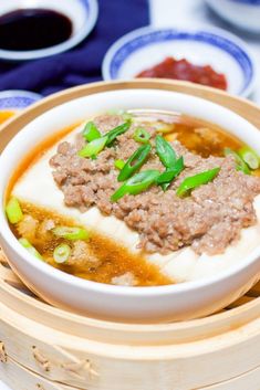 a close up of a bowl of food on a plate with chopsticks and sauce