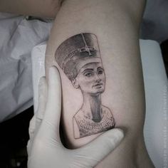 a woman's arm with a tattoo on it and a drawing of an egyptian queen