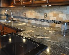 a kitchen with granite counter tops and wooden cabinets