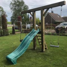 a wooden swing set with a blue slide