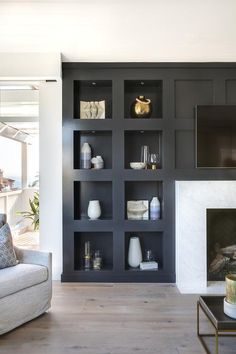 a living room filled with furniture and a fire place in front of a wall mounted tv