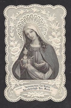 an image of the virgin mary holding a baby jesus in her arms, on a black and white doily