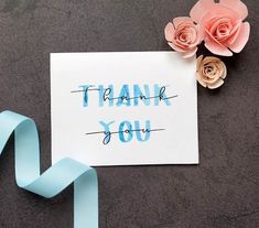 a thank you card with some flowers on top of it and a ribbon around it