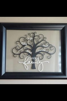 a family tree is hanging on the wall in front of a black frame with white lettering