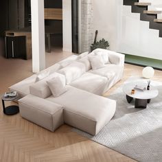 a large white couch sitting on top of a wooden floor next to a coffee table