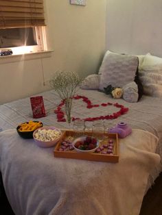 a bed topped with lots of food next to a vase filled with flowers on top of it