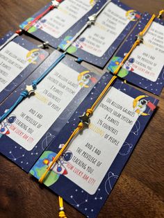 four space themed birthday party games on a wooden table with beads and tassels