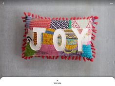 a decorative pillow with the word joy on it