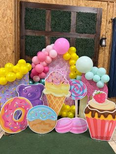 an assortment of donuts, cake and balloons for a birthday party