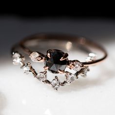 a black diamond ring sitting on top of a white surface