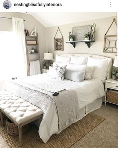 a bedroom with white bedding and lots of pillows