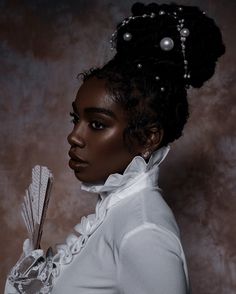 a woman in white is holding a fan