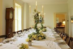 a dining room table is set with white linens and place settings for eight people