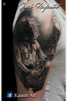 a man with a guitar tattoo on his arm and shoulder, in black and white