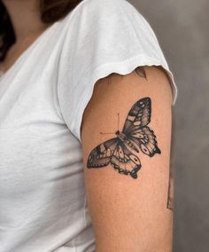 a woman with a butterfly tattoo on her arm