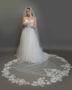 a woman in a wedding dress is standing on the floor with her veil over her face