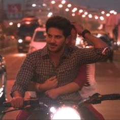 a man riding on the back of a motorcycle down a street