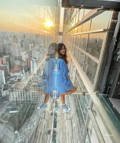 a woman standing on top of a tall building