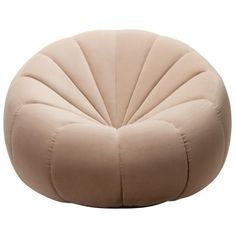 a beige round chair sitting on top of a white floor