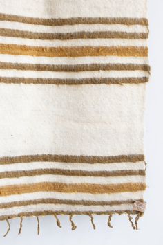 a white and brown striped rug with tassels