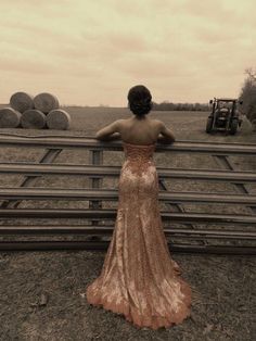 a woman standing in front of a wooden fence