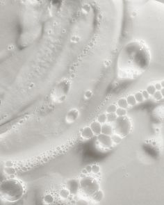 an image of water and bubbles on a white surface that looks like something out of space