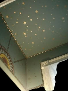 the ceiling has stars painted on it and is blue with gold trimmings,