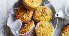 several muffins on a plate next to a cup of coffee