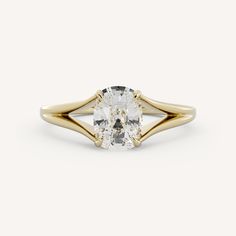 a yellow gold ring with an oval cut diamond