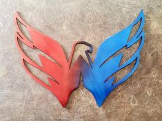 two red and blue metal wings sitting on top of a table