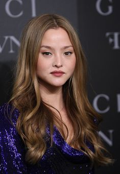 a woman with long hair wearing a purple dress