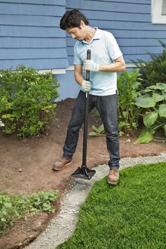 a man standing in front of a blue house with a lawn mower on it's head