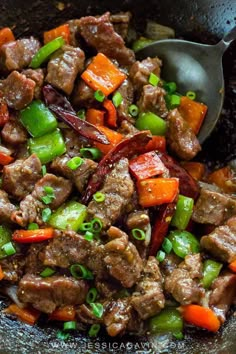 beef stir fry with peppers and onions in a skillet