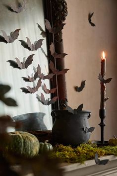 a candle is lit in front of a mirror with bats on it and other decorations