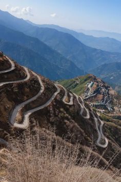 the road is winding in both directions on the mountain side