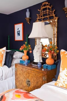 a bedroom decorated in blue and orange with two lamps on the nightstands next to each other