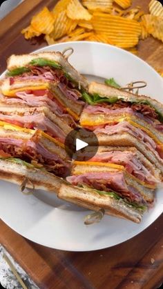 a white plate topped with a cut in half sandwich on top of a wooden cutting board