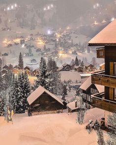 a snow covered town at night in the mountains