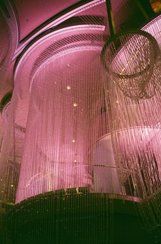 the chandelier is hanging from the ceiling in the room with pink lights on it