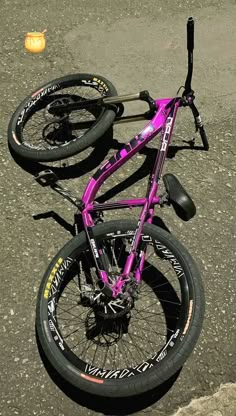 a purple bike parked on top of a parking lot