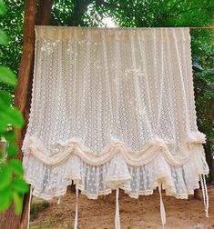 a white curtain hanging from the side of a tree