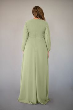 a woman in a long green dress is facing away from the camera, with her back turned