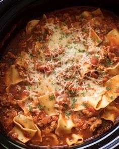 a crock pot filled with pasta, meat and cheese on top of sauce in it