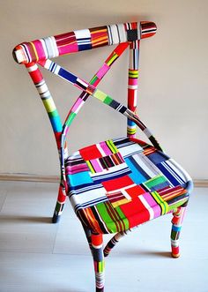 a multicolored chair sitting on top of a white floor next to a wall