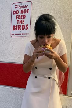 a woman in a white dress eating food