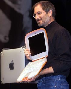 a man holding an apple computer in his hands